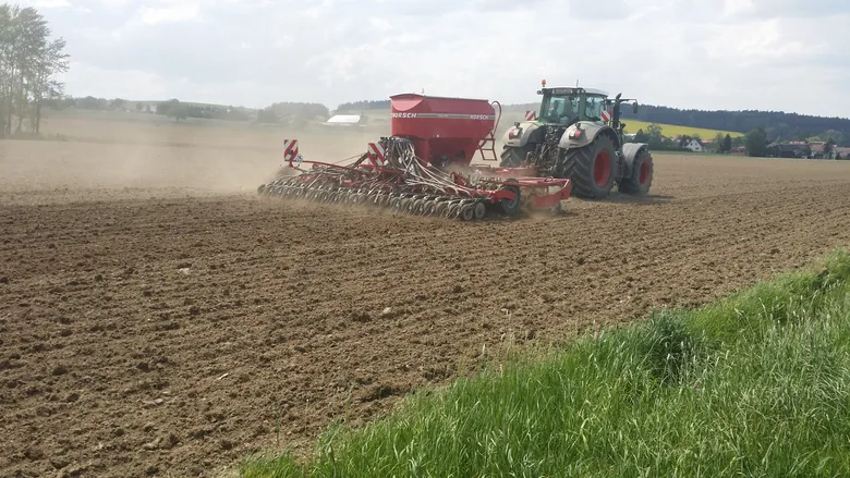 Traktor mit Sämaschine auf einem Acker – Landwirtschaft, Ackerbau